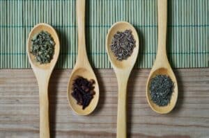 Picture showing a variety of herbs helpful for pms symptoms including lavender on wooden spoons